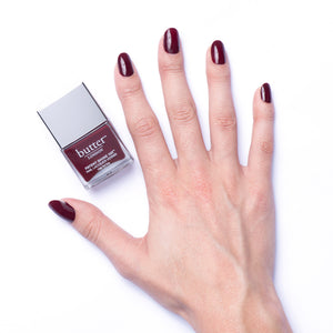 butter LONDON - Afters (Dark Red) Patent Shine 10X Nail Lacquer - Lifestyle Image - Full White Background.